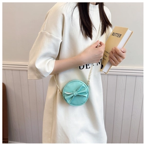 Détail du mini sac rond bleu clair avec nœud et bandoulière en perles pour petites filles
