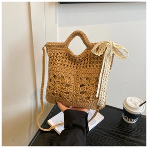 Close-up of floral crochet handbag with beige lace scarf accent and crossbody strap