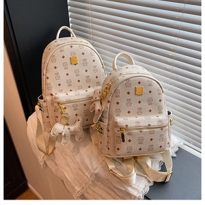Dettaglio del set zaino color crema con motivi a orsetto, zip dorate e ciondolo a cucciolo