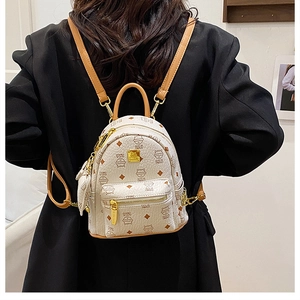 Detailed back view of a mini cream backpack with cute cat prints on a black blazer