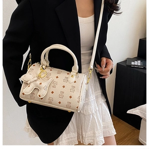 Detail of Boston bag showing kitten print, leather texture and gold hardware on a model
