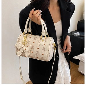 Cream white Boston bag featuring cat prints and a charm accessory on model shoulder