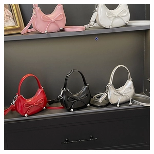 Detailed display of five colorful mini crescent handbags with leather bow and metallic beads