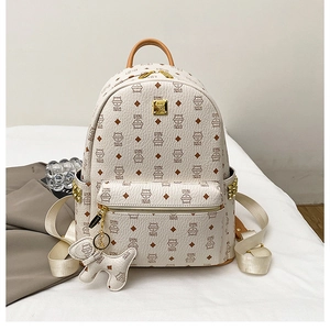 Détail du sac à dos crème avec imprimé monogramme chat marron et petit pendentif chien