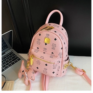 Detail of pink lychee leather backpack with kitten pattern and cute dog charm accessory