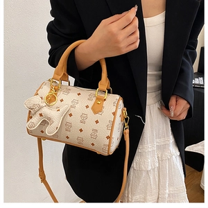 Close-up of Boston bag featuring cartoon cat patterns and detachable dog charm