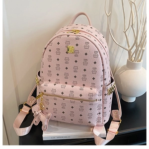 Détail d'un sac à dos rose avec imprimés de chats, dorure et charm chat assorti