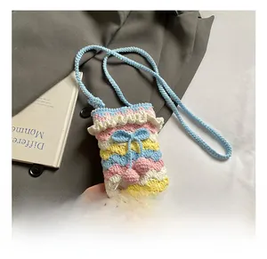 Macro detail of handmade crochet shoulder bag with rainbow wavy patterns and blue bow