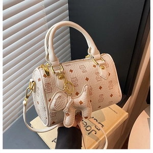 Close-up of cream Boston bag with cartoon cat print and golden hardware detailing