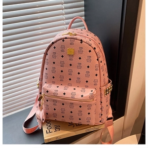 Détail du sac à dos rose avec imprimés de chats, clous dorés et logo métallique