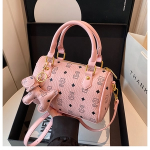 Detailed view of pink Boston bag featuring cartoon cat prints and matching cat charm accessory