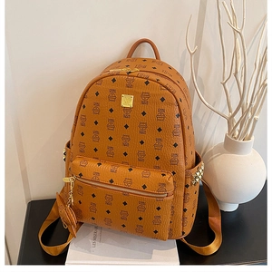 Détail d'un sac à dos en cuir PU marron avec motifs de chat, clous et pendentif mignon