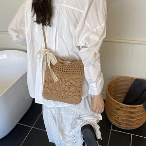 Brown crochet shoulder bag with floral openwork patterns and a beige lace bow accent