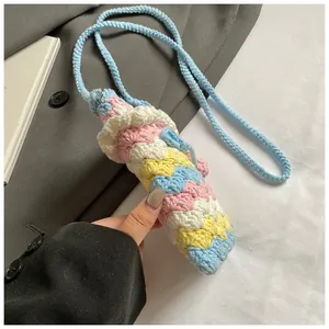 Detail shot of a handmade crochet rainbow bucket bag with pastel knit wave patterns