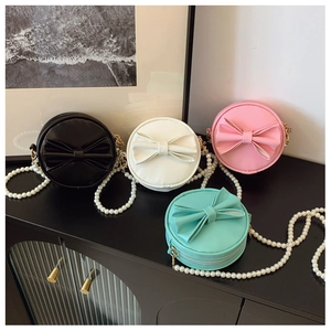 Vue détaillée de mini sacs ronds pour filles avec de grands nœuds et chaînes de perles