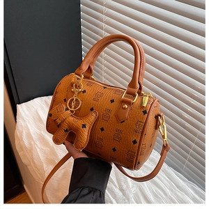 Detail of caramel boston bag featuring cat monogram patterns and leather dog charm