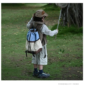 Kid's outdoor contrast backpack with drawstring closure shown in a natural park setting