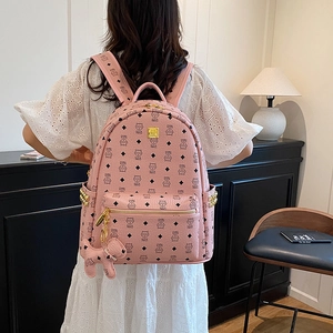 Sac à dos en cuir PU rose avec motif chat et clous dorés porté par un mannequin chic