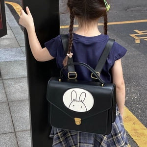 Close-up of vintage style black leather kids backpack with a cute rabbit character print