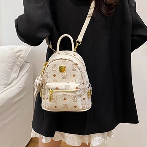 Mini backpack with cat print and gold zippers shown on a model's black jacket