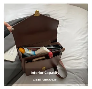 Detailed interior of vintage brown leather satchel showing tablet and daily essentials