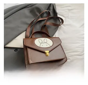 Close-up of brown vintage children backpack featuring a cute white rabbit patch and gold lock
