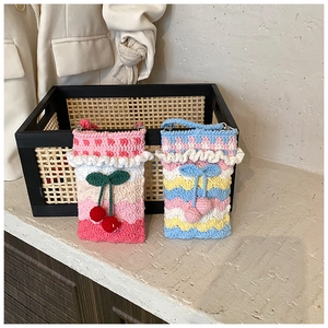 Detail of handmade crochet shoulder bags with cherry charms and rainbow weave texture