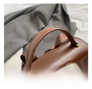 Detail view of reinforced leather handle and cute rabbit print on a brown vintage backpack