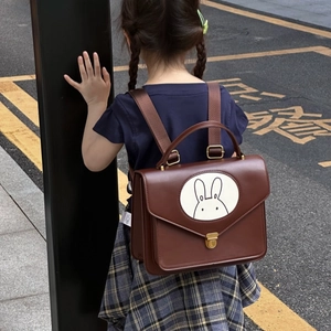 Top-down view of a vintage dark brown leather kids backpack with cute rabbit illustration