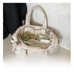 Spacious interior of beige quilted diaper bag with silver dots and storage pockets