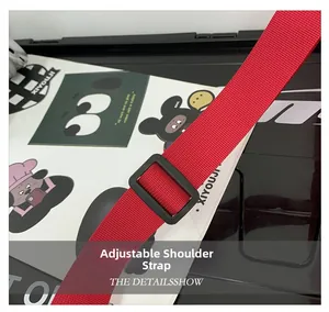Dettaglio della tracolla regolabile in nylon rosso con fibbia in plastica nera