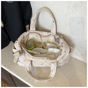 Detailed interior of quilted diaper bag showing storage pockets with bottle and straps