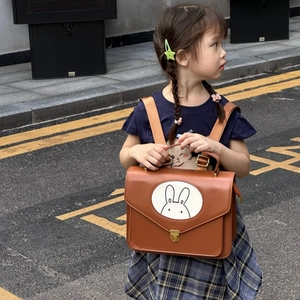 Detail of vintage brown PU leather children backpack with cute rabbit graphic and metal buckle