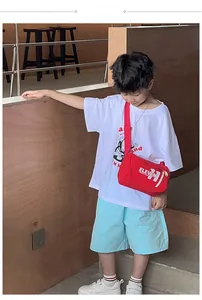 Dettaglio della borsa a tracolla rossa per bambini con stampa ELEVEN e cinturino