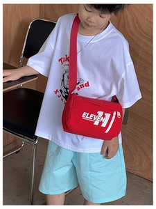 Dettaglio della borsa a tracolla rossa per bambini in tela con scritta Eleven 11 bianca