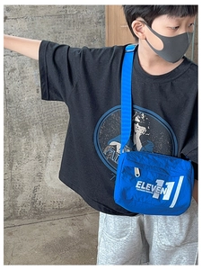Dettaglio della borsa a tracolla in nylon blu con tracolla regolabile e stampa Eleven 11