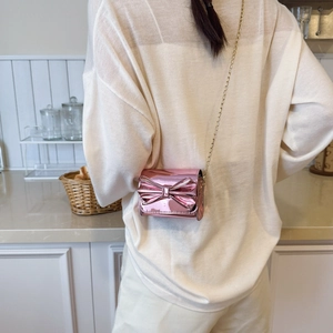 Mini metallic pink bow crossbody bag for girls with gold chain strap on model