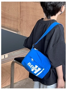 Dettaglio borsa a tracolla blu per bambini con stampa ELEVEN 11 e cinturino in nylon