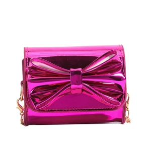 Cute pink metallic patent leather crossbody bag with a large bow and gold chain strap