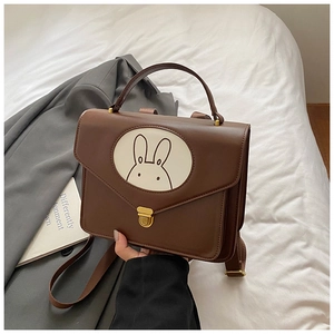 Detail view of brown retro kids backpack with a cute bunny graphic and metal clasp