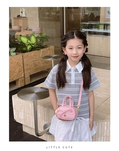 Detailed close-up of pink mini tote bag with bow and gold heart pendant for kids