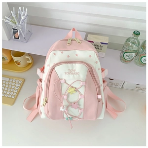 Pink and beige school backpack with star pattern and embroidery in classroom setting
