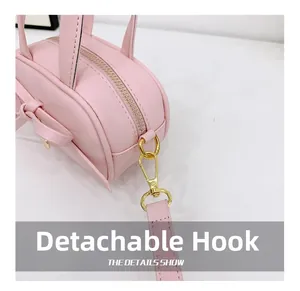 Close-up of pink mini bag showing the gold metal hook and detachable shoulder strap detail