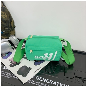 Dettaglio della borsa a tracolla in nylon verde con stampa di lettere e cinturino