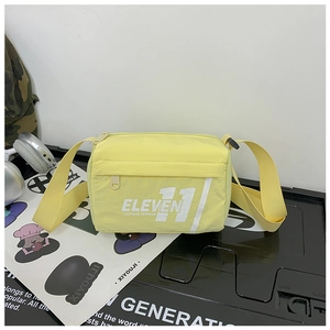 Dettaglio borsa a tracolla in nylon giallo chiaro con stampa e tasca frontale zip