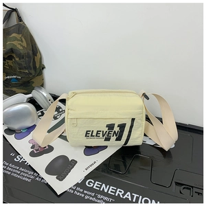 Dettaglio della borsa a tracolla in nylon giallo crema per bambini con scritte ELEVEN 11