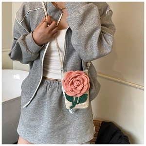 Détail du sac bandoulière tricoté main avec fleur rose 3D et fermeture éclair en bas