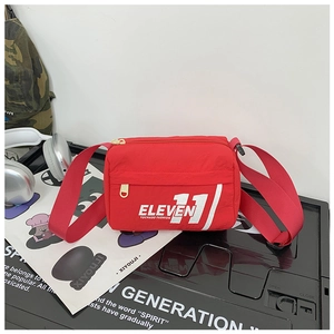 Dettaglio della borsa a tracolla rossa in nylon per bambini con scritte alla moda