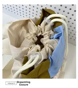 Dettaglio dello zaino color-block con chiusura a coulisse e fermacorda bianco