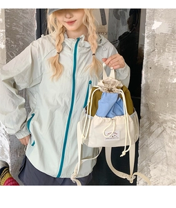 Zaino alla moda con coulisse e blocchi di colore tenuto in mano da una modella